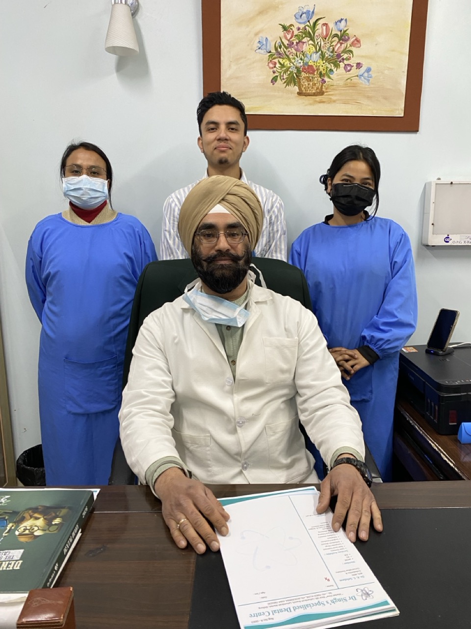 Clinic team standing behind Dr. Kamaljeet Singh Sehdave